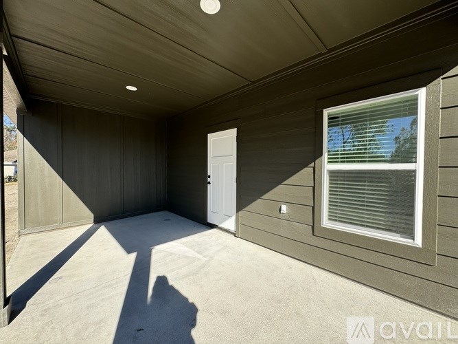 A room with a door and a window with blinds.