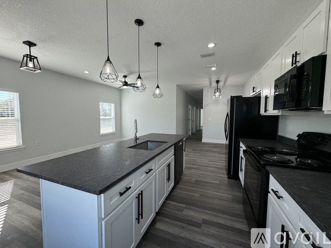 A kitchen with black countertops and white cabinets.