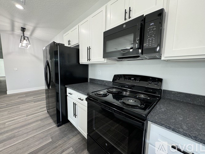 A black stove top oven with a black microwave above it.