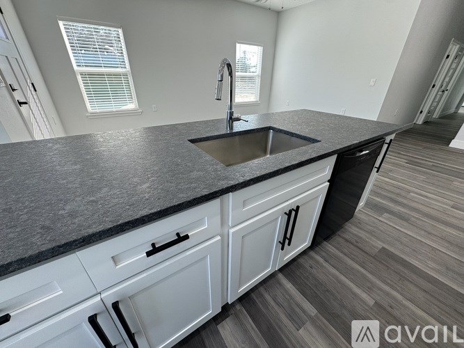 A kitchen with a granite countertop and white cabinets.