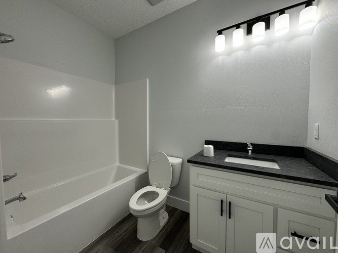 A white bathroom with a toilet, sink, and bathtub.