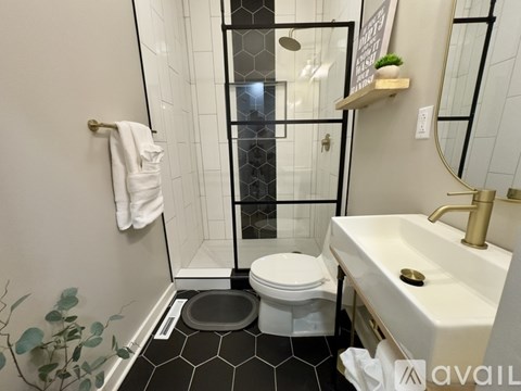 A bathroom with a toilet, sink, and mirror.
