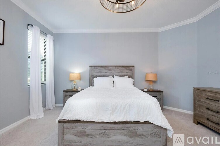 A bedroom with a large bed and a chandelier.