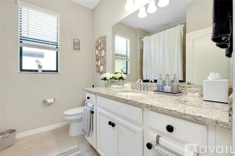 A bathroom with a toilet, sink, and mirror.