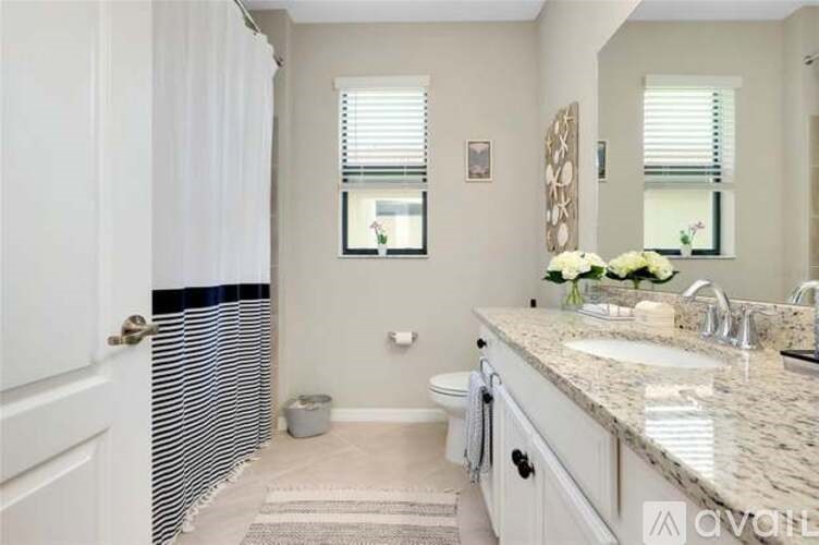 A bathroom with a toilet, sink, and mirror.