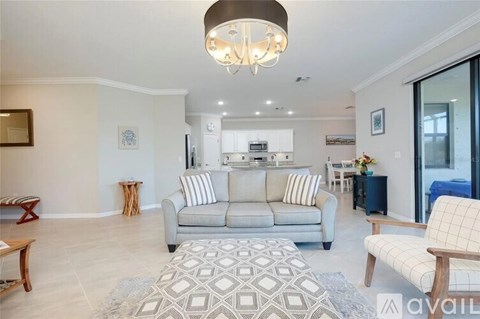 A living room with a grey couch and a patterned rug.