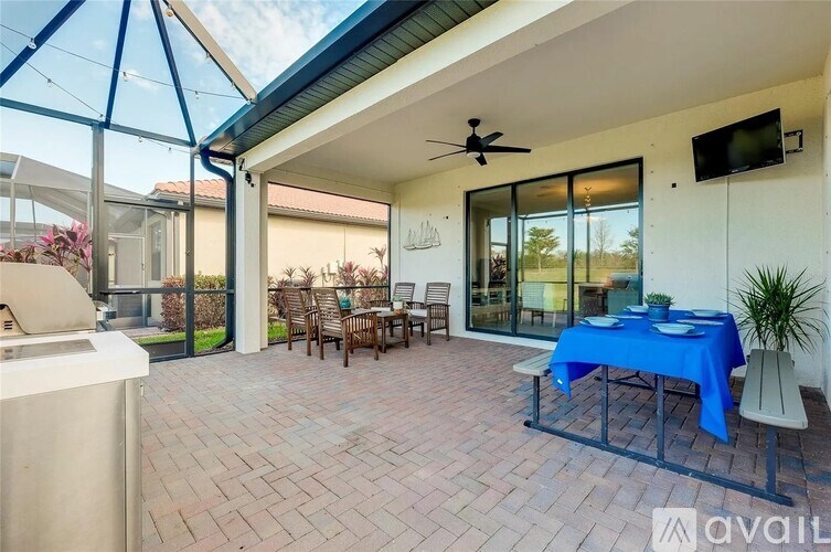 A patio with a table set for dining and a ceiling fan.