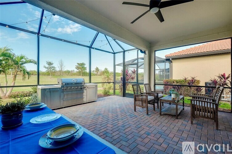 A patio with a table set for a meal and a grill in the background.