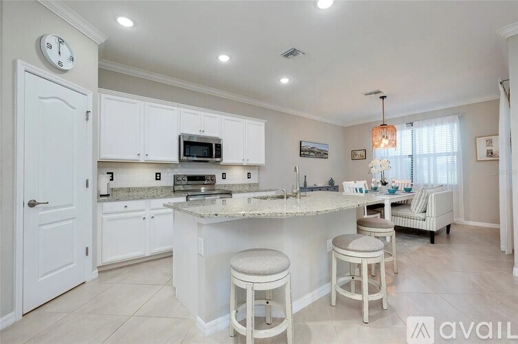 A kitchen with white cabinets and a marble countertop.