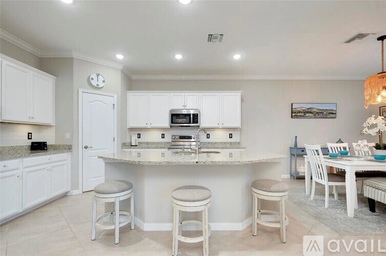 A kitchen with white cabinets and a granite countertop.