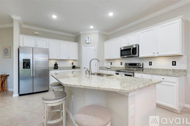 A kitchen with granite countertops and white cabinets.
