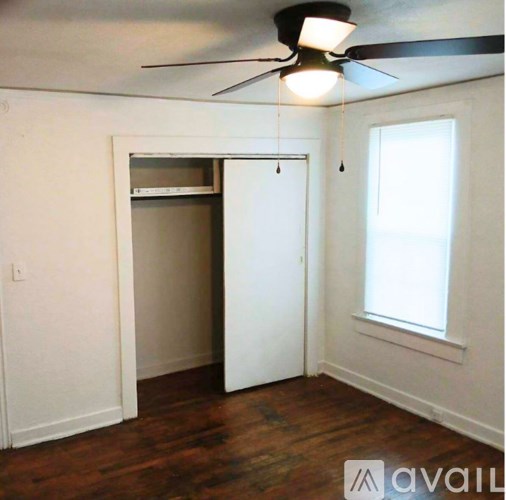 A room with a ceiling fan and a window.