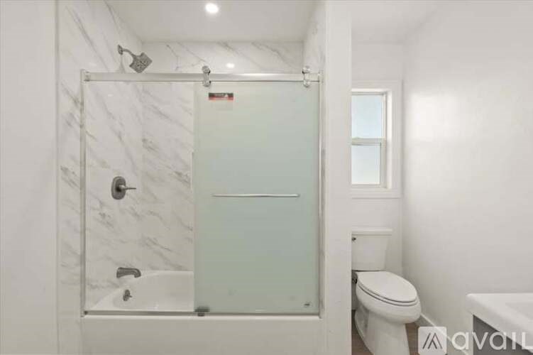 A white bathroom with a walk-in shower and toilet.