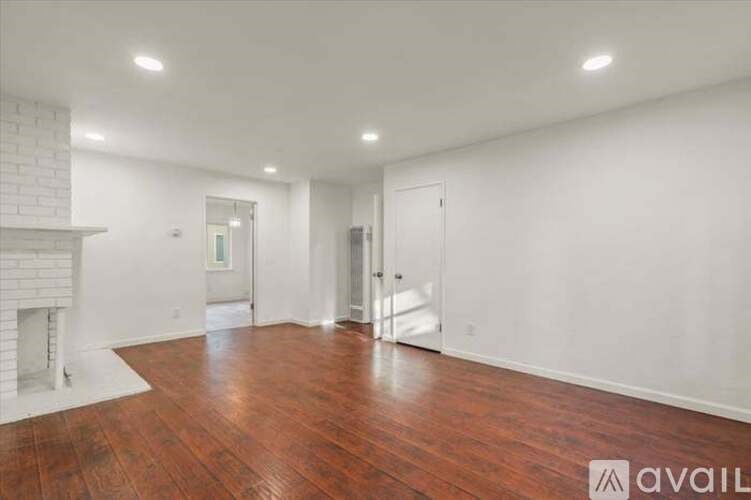 A room with a fireplace and wood flooring.