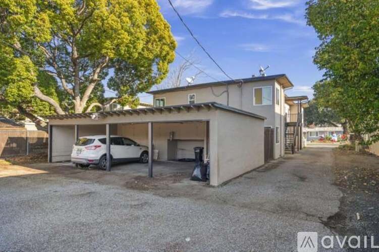 A car is parked in a driveway in front of a house.