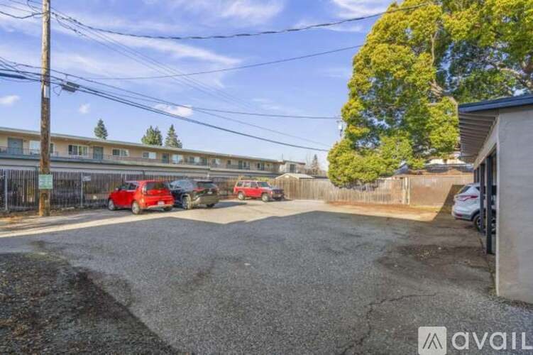A parking lot with cars and a building in the background.