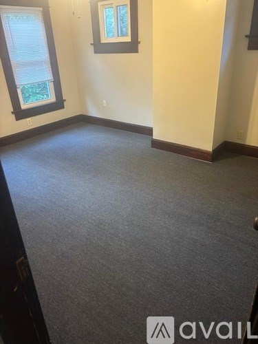 A room with a carpeted floor and a window.