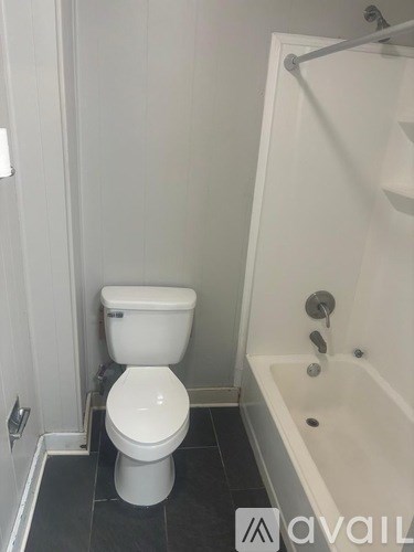 A white toilet sits next to a bathtub in a bathroom.