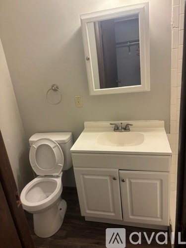 A white toilet and sink in a small bathroom.