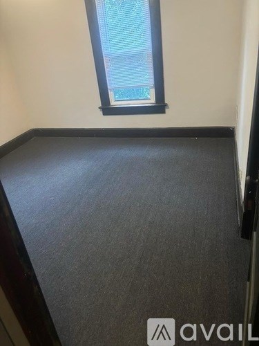 A room with a carpeted floor and a window.