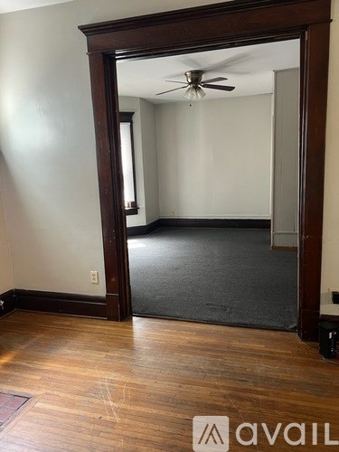 A room with a wooden floor and a ceiling fan.
