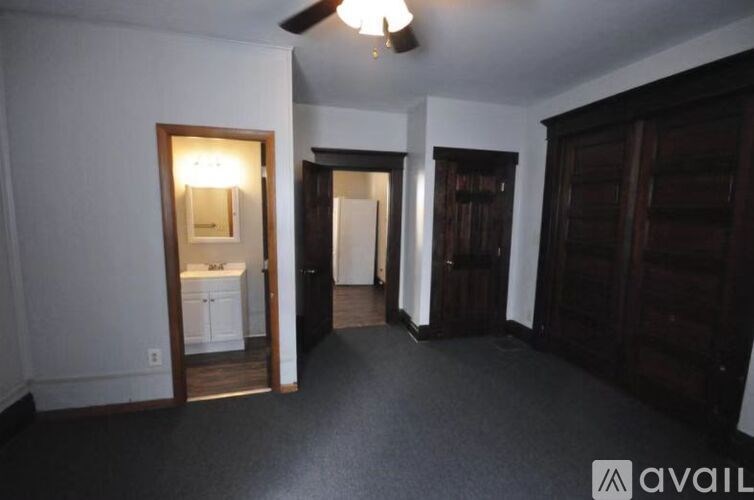 A room with a white wall and a wooden door.