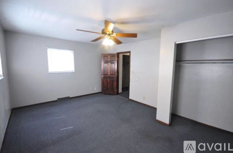 A room with a ceiling fan and a door.