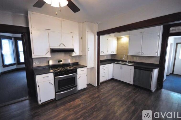 A kitchen with white cabinets and black countertops.