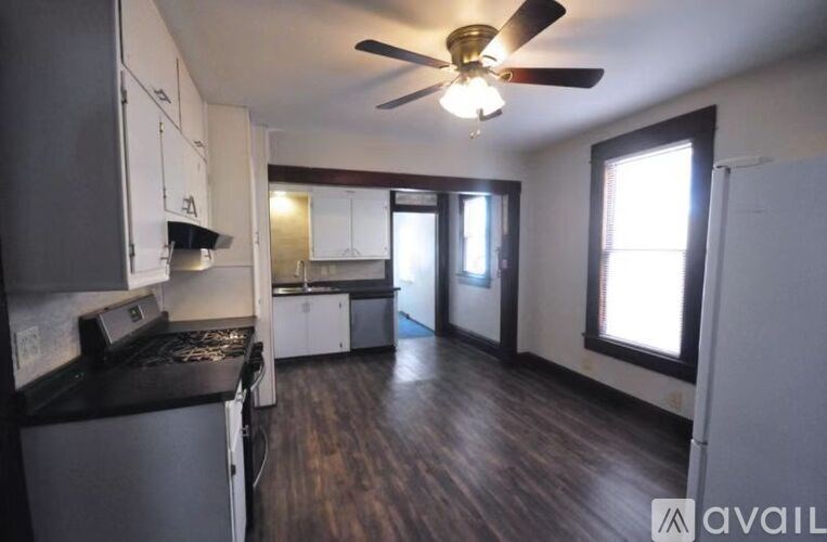 A kitchen with a black stove top oven and white cabinets.