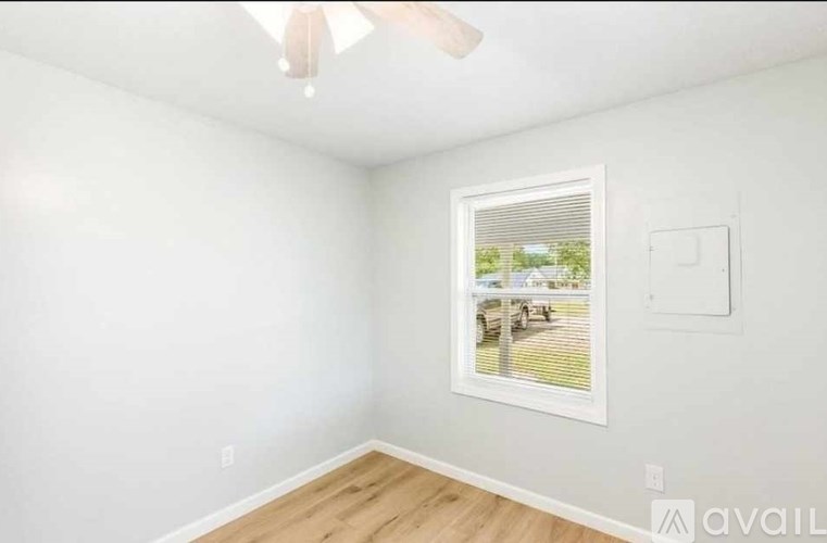 A room with a window and a ceiling fan.