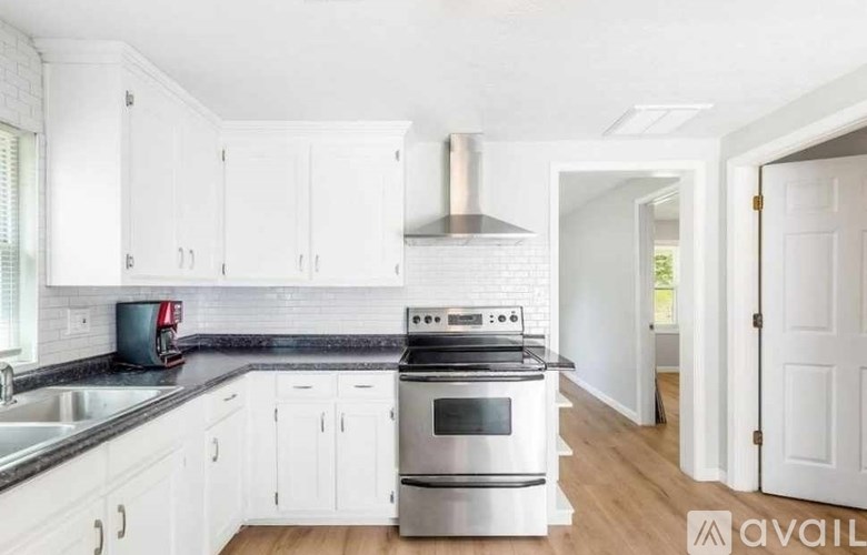 A kitchen with white cabinets and a stainless steel oven.