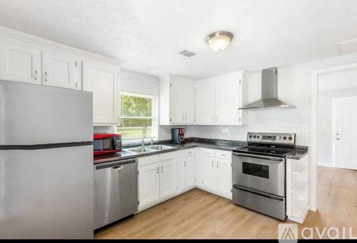 A kitchen with white cabinets and stainless steel appliances.