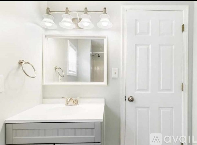 A white bathroom vanity with a mirror above it.