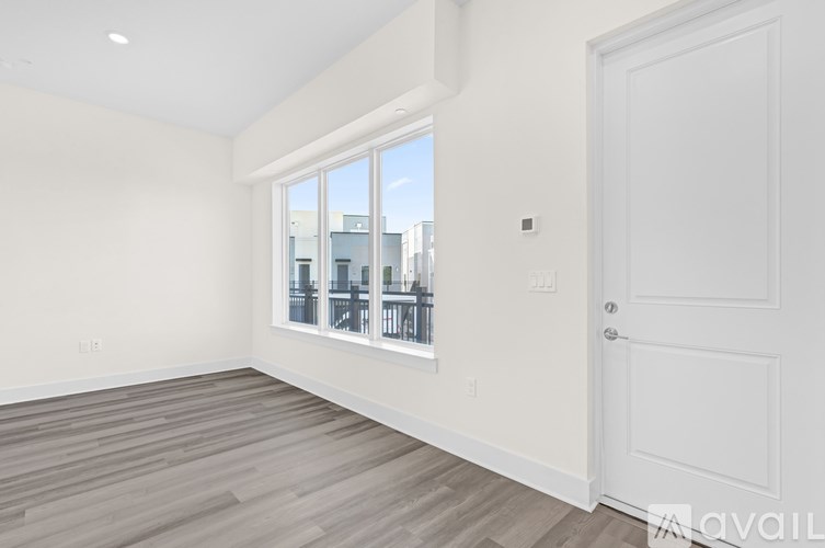 A room with a white door and a window overlooking a cityscape.