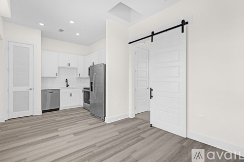 A kitchen with white cabinets and a wooden floor.