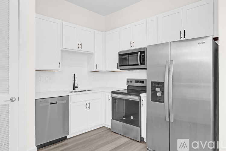 A kitchen with white cabinets and stainless steel appliances.