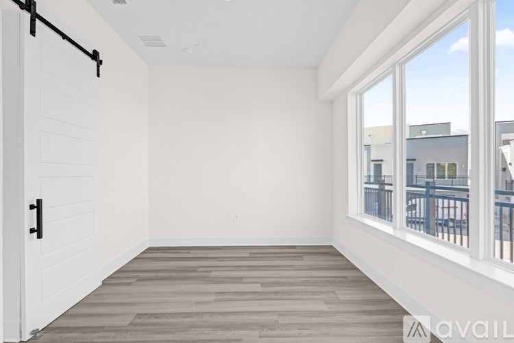 A room with a sliding door and a window overlooking a balcony.
