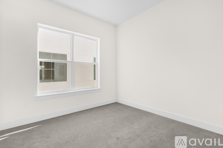 A room with a window and carpeted floor.