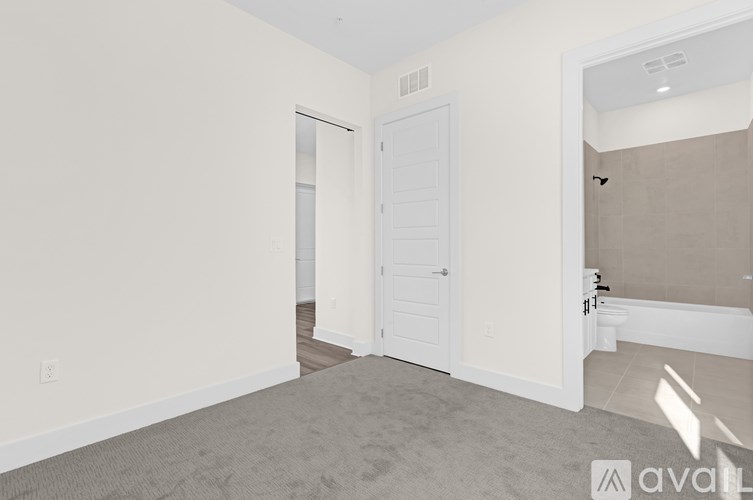 A room with a white door and carpeted floor.