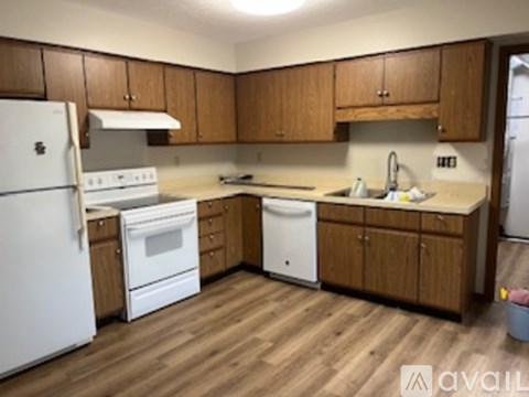 A kitchen with wooden cabinets and white appliances.