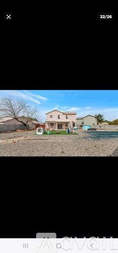 A house with a blue sky and a tree in the background.