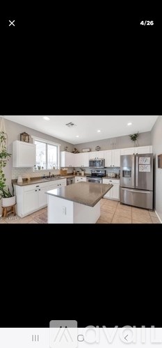 A modern kitchen with white cabinets and a central island.
