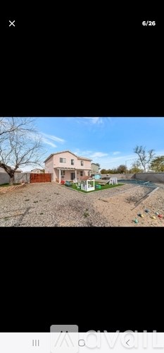 A house with a red roof and a white fence is visible.