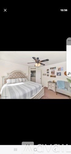 A bedroom with a bed, dresser, and ceiling fan.