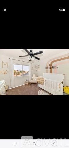 A baby's room with a white crib and a ceiling fan.