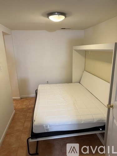 A bed with a white mattress and black metal frame in a room.