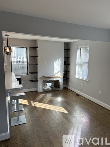 A living room with a grey floor and white walls.
