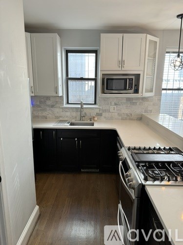 A kitchen with black cabinets and a white countertop.