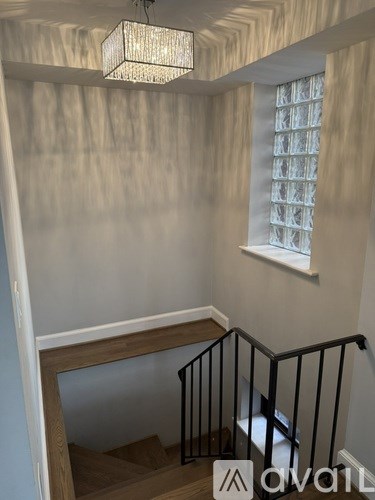 A staircase with a black railing and wooden steps.