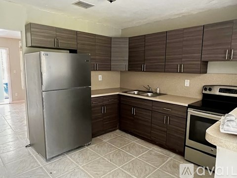 A kitchen with a refrigerator, oven, and microwave.